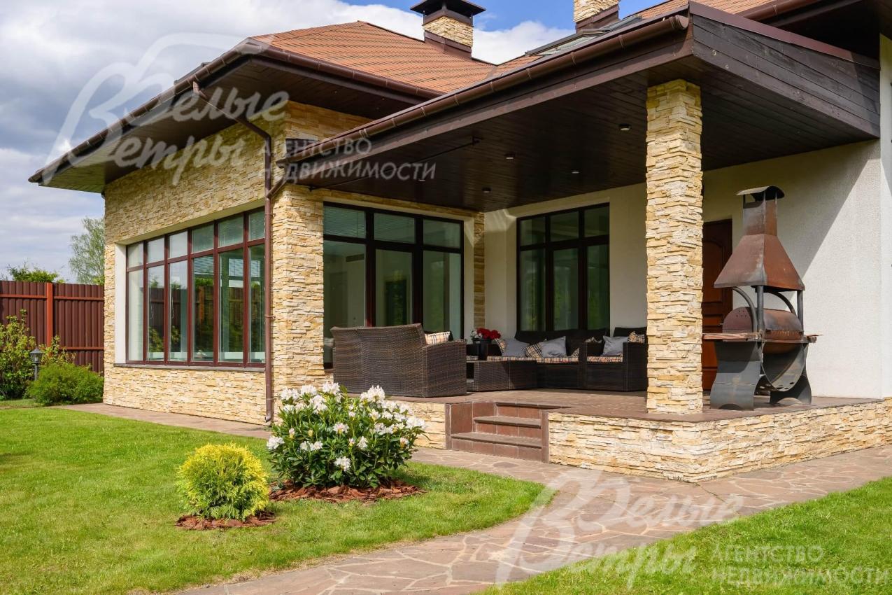 Гостевой дом с крытой террасой с зоной барбекю.