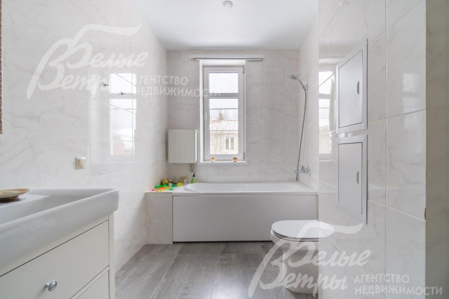 Просторный санузел с отделкой под белый мрамор