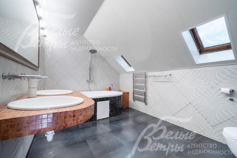 Санузел на втором этаже с большой ванной Hoesch и двойной раковиной оформлен в светлых тонах