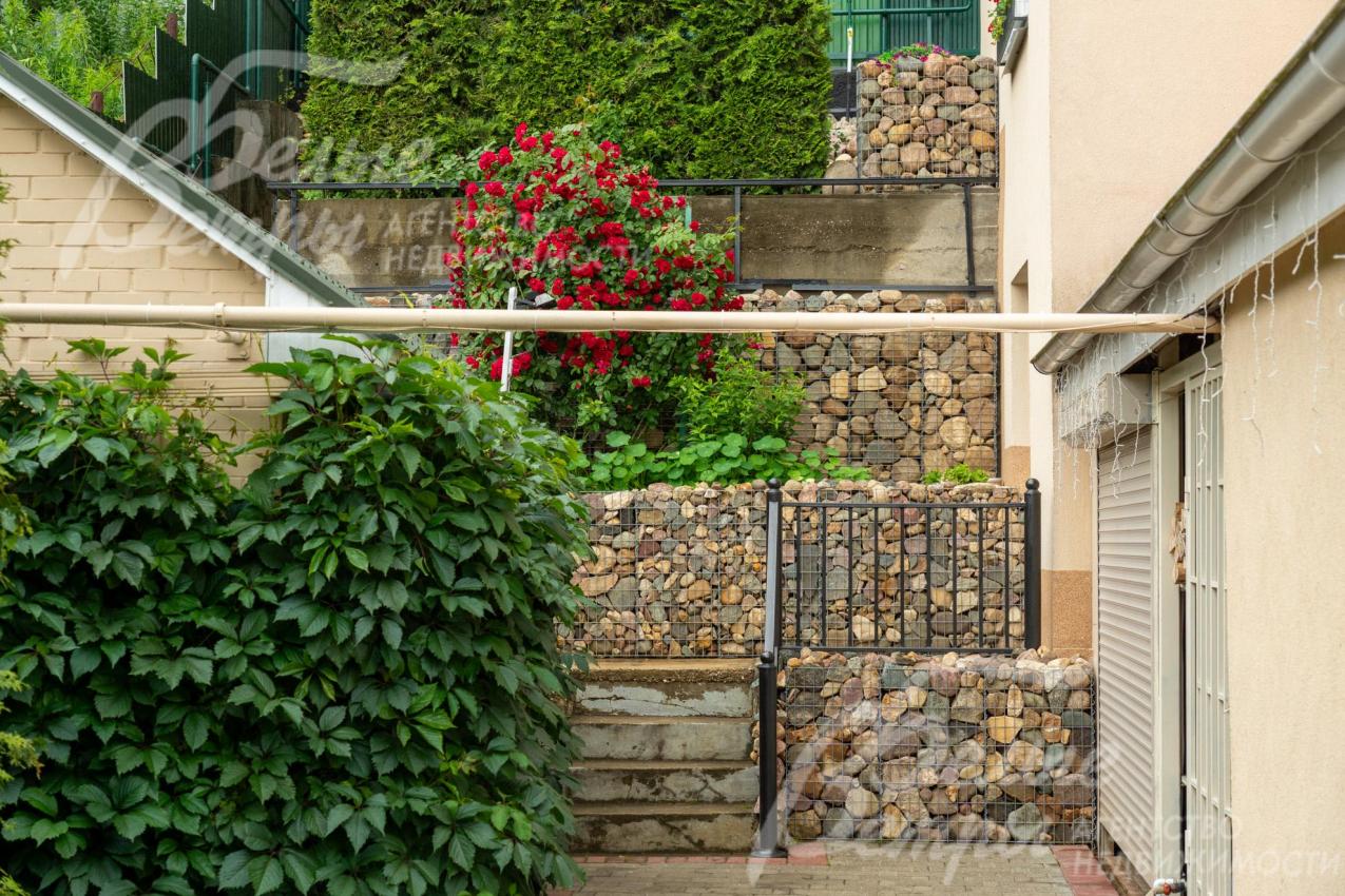 На участке - динамичная композиция зелёных насаждений с непрерывным цветением на протяжении всего сезона