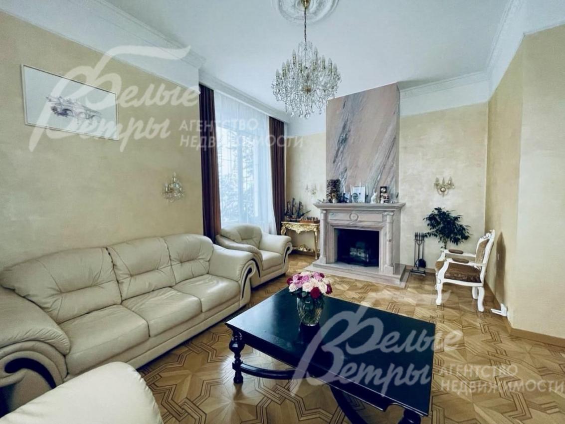 Гостиная с камином, отделанным розовым мрамором.