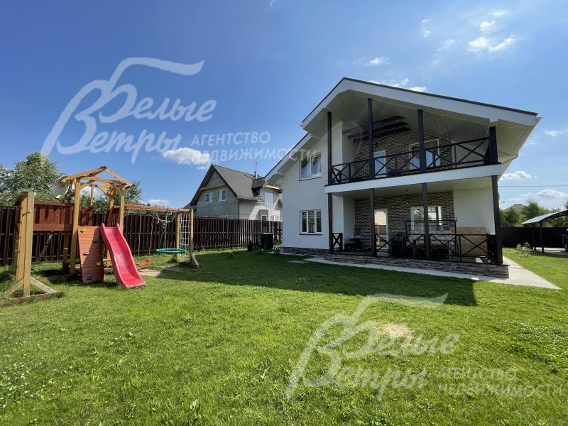 На участке газон и современная детская игровая площадка