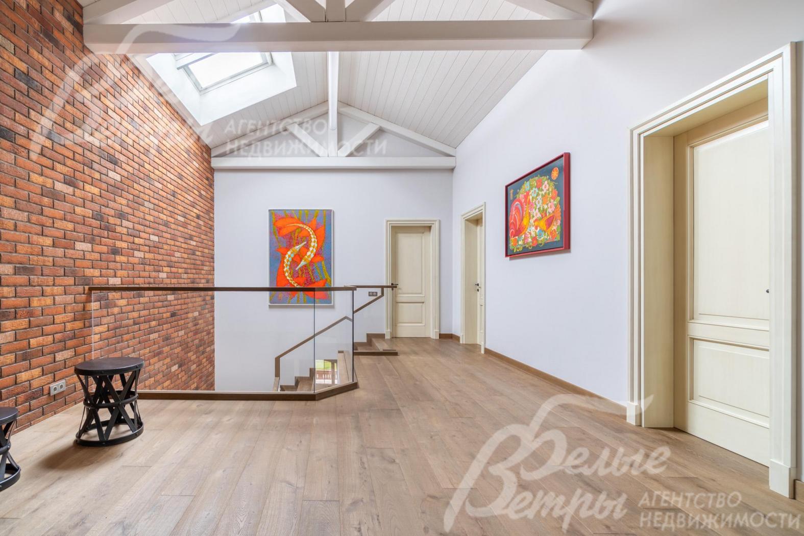 Холл второго этажа с акцентной стеной, оформленной в стиле лофт, массивными балками  и мансардными окнами Velux. Двери - из массива каштана с сатиновым покрытием