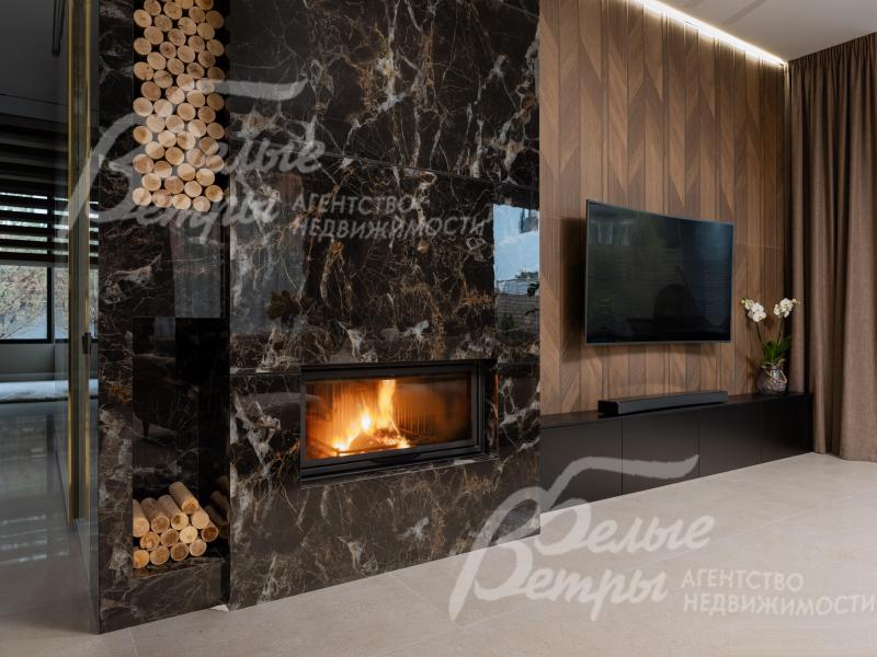 Гостиную украшает камин, облицованный керамогранитом под мрамор