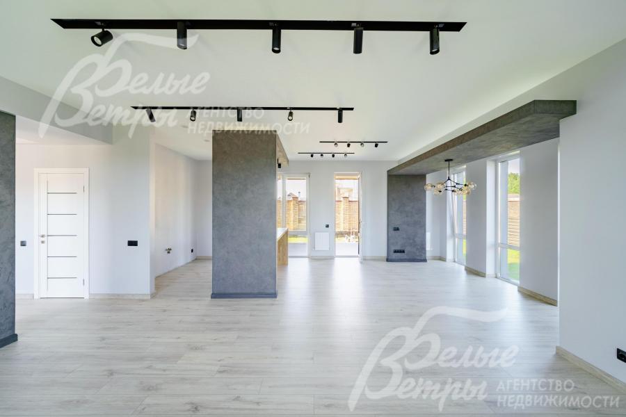 Просторная гостиная. Выполнена современная отделка в светлых тонах