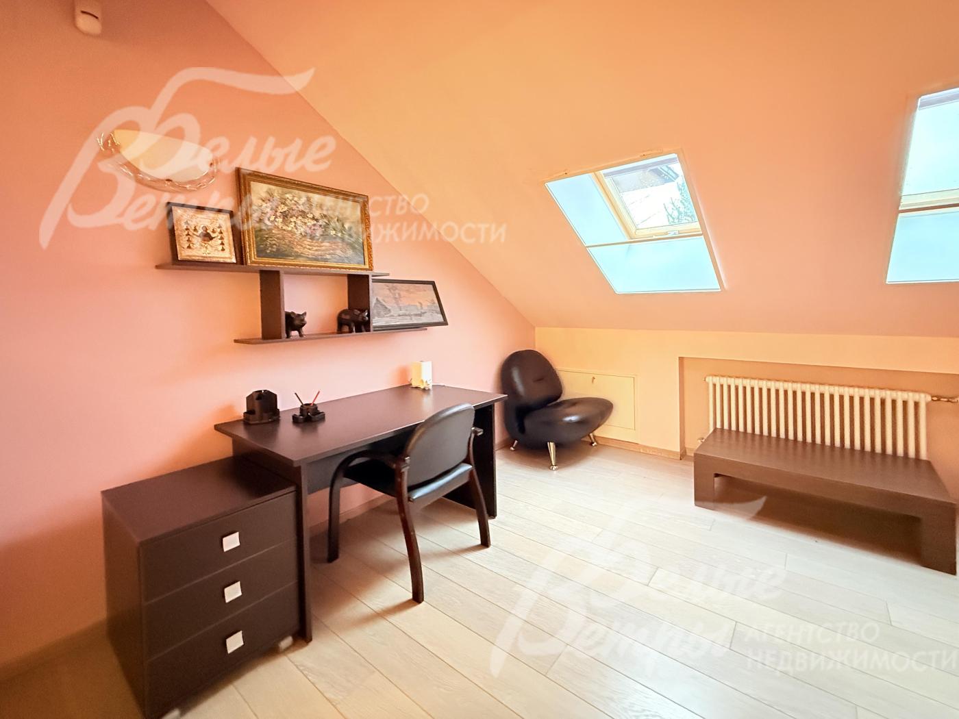 Одна из спален оборудована под рабочее место. Потолки наклонной формы создают уютную атмосферу мансарды