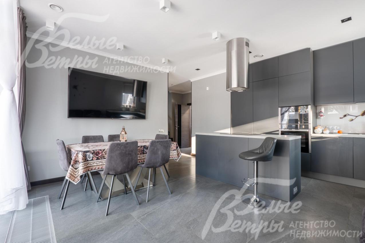 Интерьер кухни‑столовой выполнен в благородных бело‑серых оттенков, предусмотрена многоуровневая система освещения