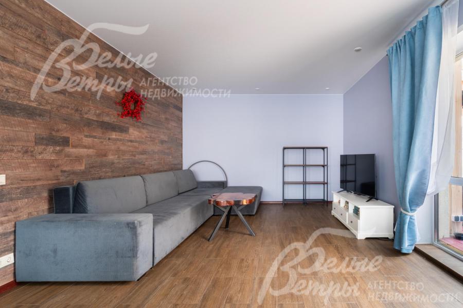 В гостиной размещены диван и стол ручной работы из ценных пород дерева с эпоксидной смолой