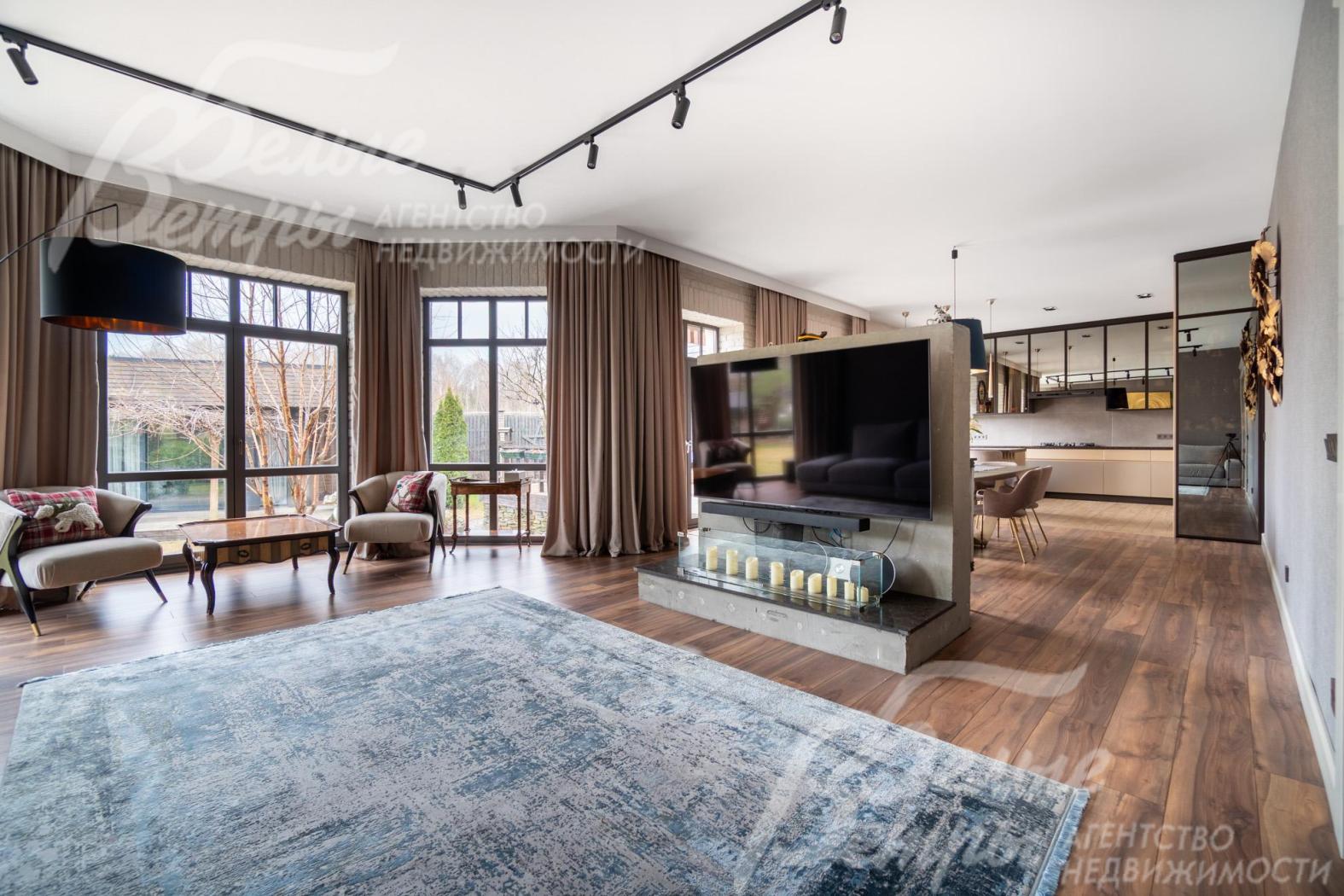 На отдельной акцентной стене в гостиной расположен широкоформатный телевизор и биокамин