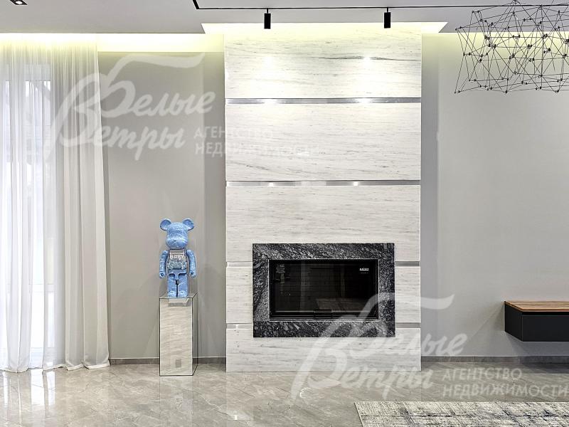 Гостиную украшает дровяной камин гильотинного типа, широкий портал отделан натуральным мрамором