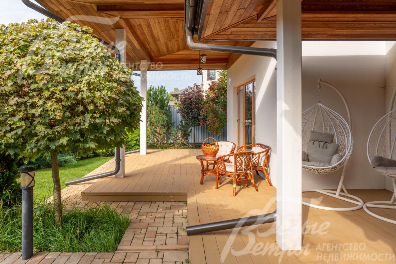 Крытая терраса на первом этаже (слева от главного входа) с садовой мебелью