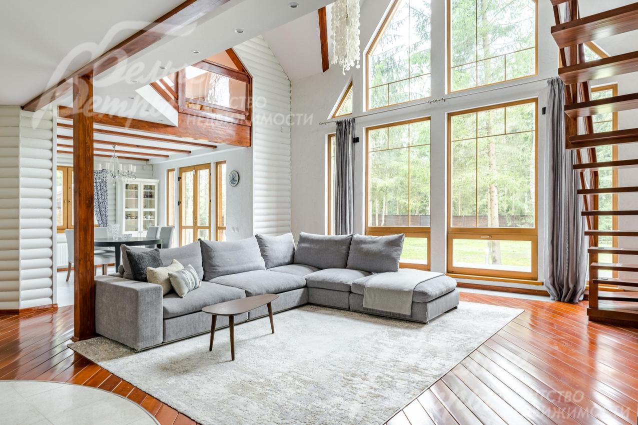 Двухсветная гостиная наполняет дом естественным светом. Огромные стекло-пакеты из лиственницы