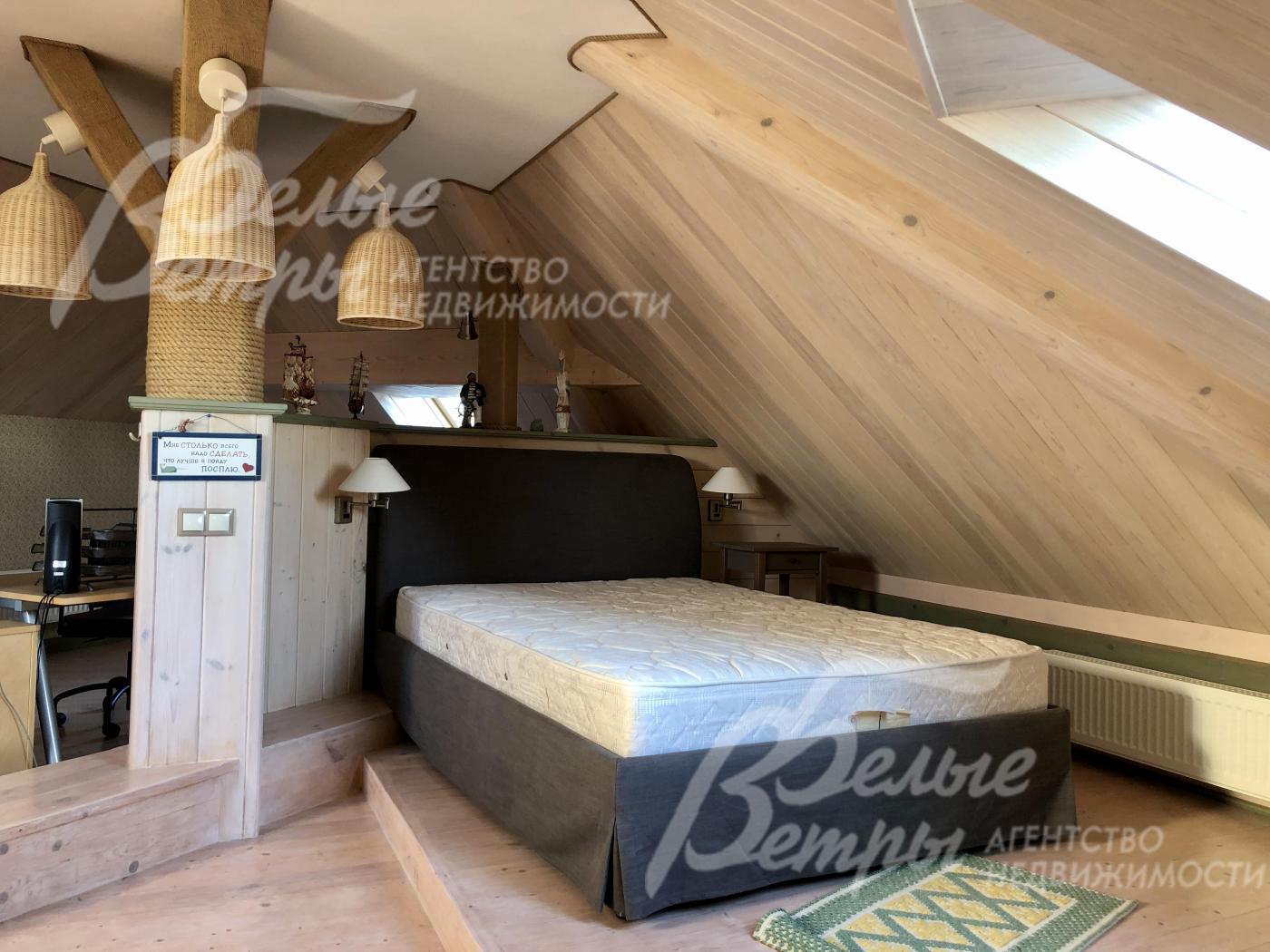 Зона для отдыха и релакса с кроватью и столом на мансарде