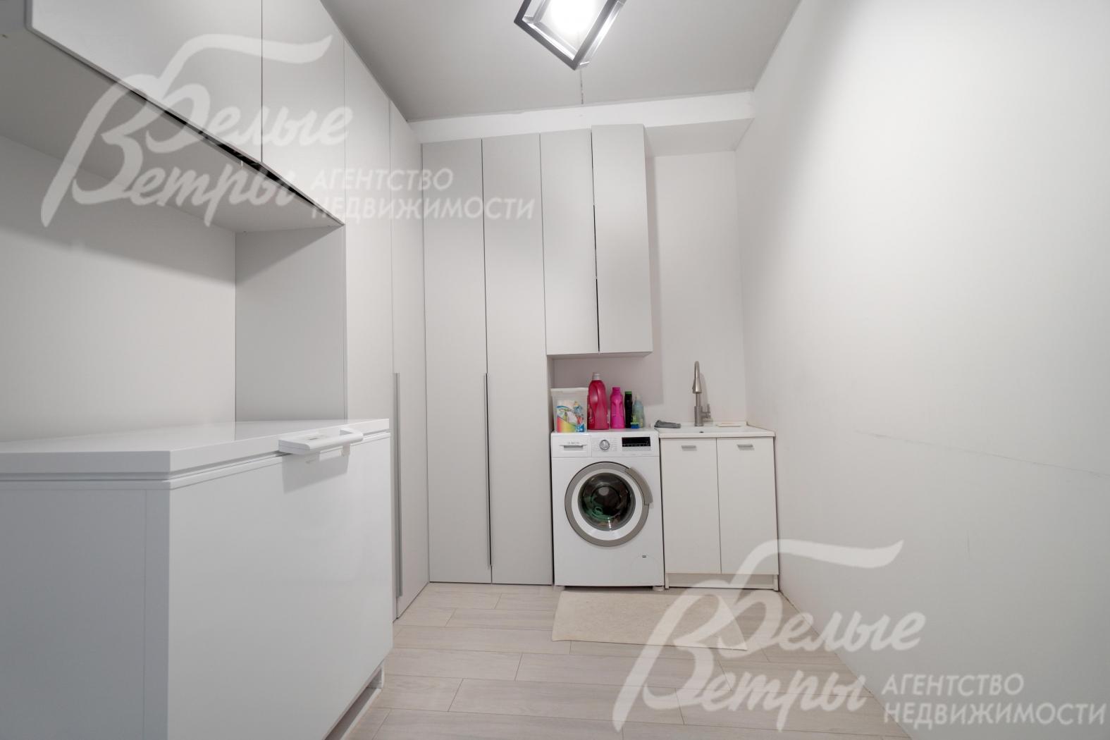 Постирочная на 1-м этаже оборудована стиральной машиной и системой хранения