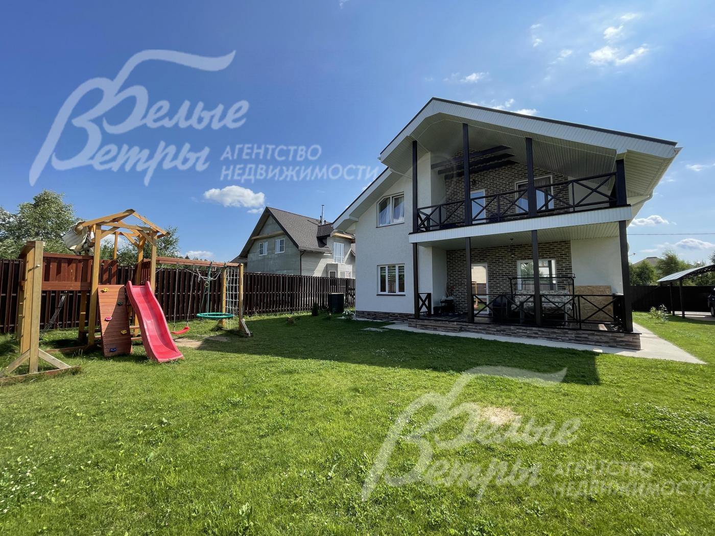 На участке газон и современная детская игровая площадка