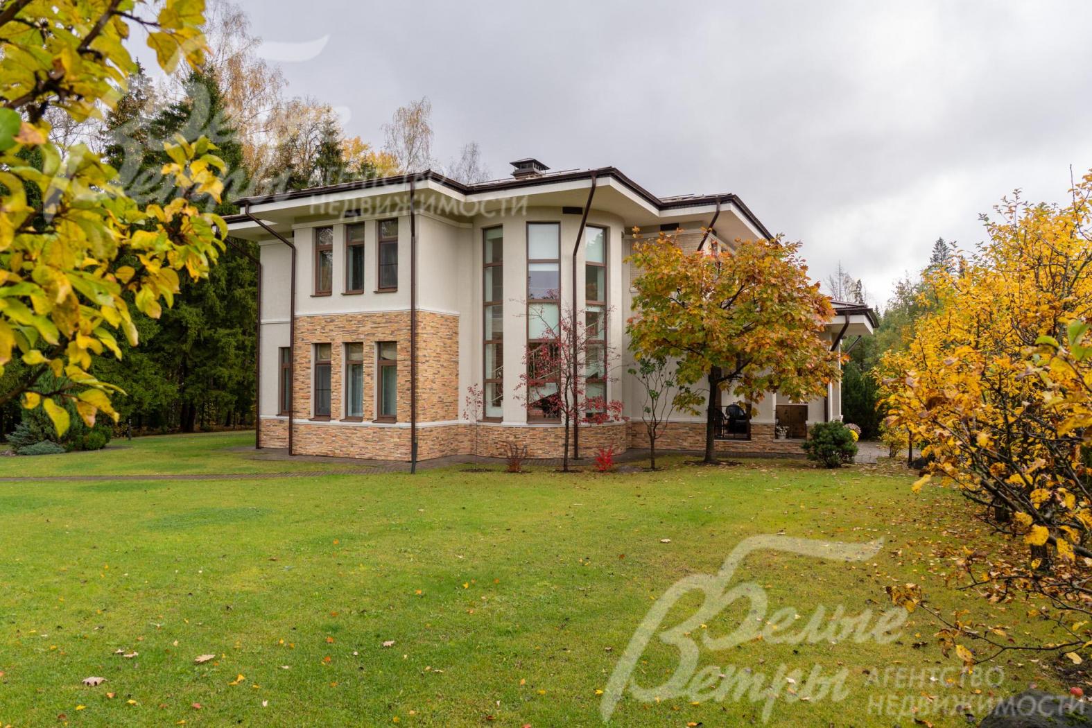 Дом стоит на просторном участке с ландшафтным дизайном в духе классического английского сада