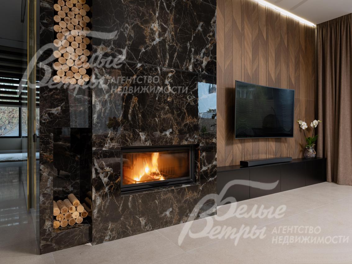 Гостиную украшает камин, облицованный керамогранитом под мрамор