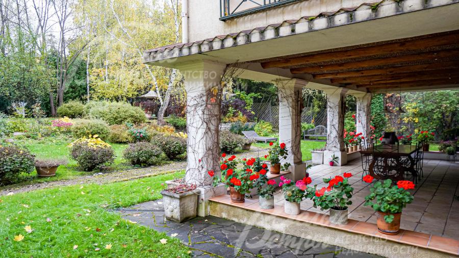 Великолепная веранда с цветущими геранями и выходом на участок