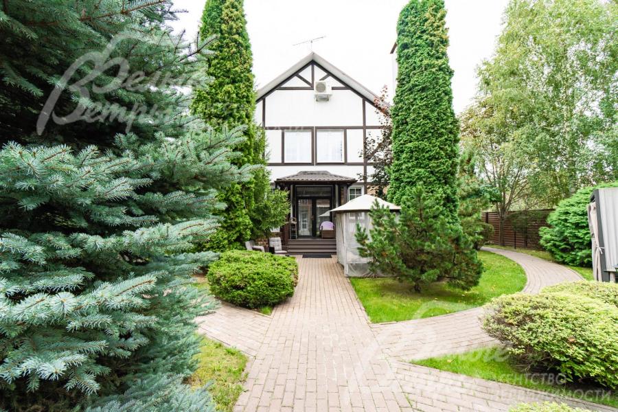 Красивый парковый участок со множеством деревьев и декоративных кустарников.