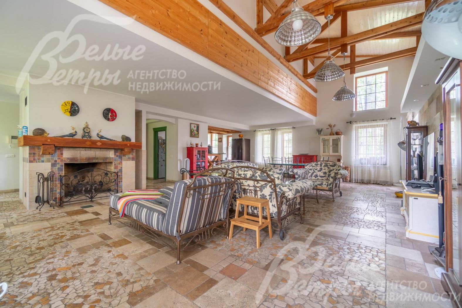 Гостиную со вторым светом украшает камин, отделанный травертином