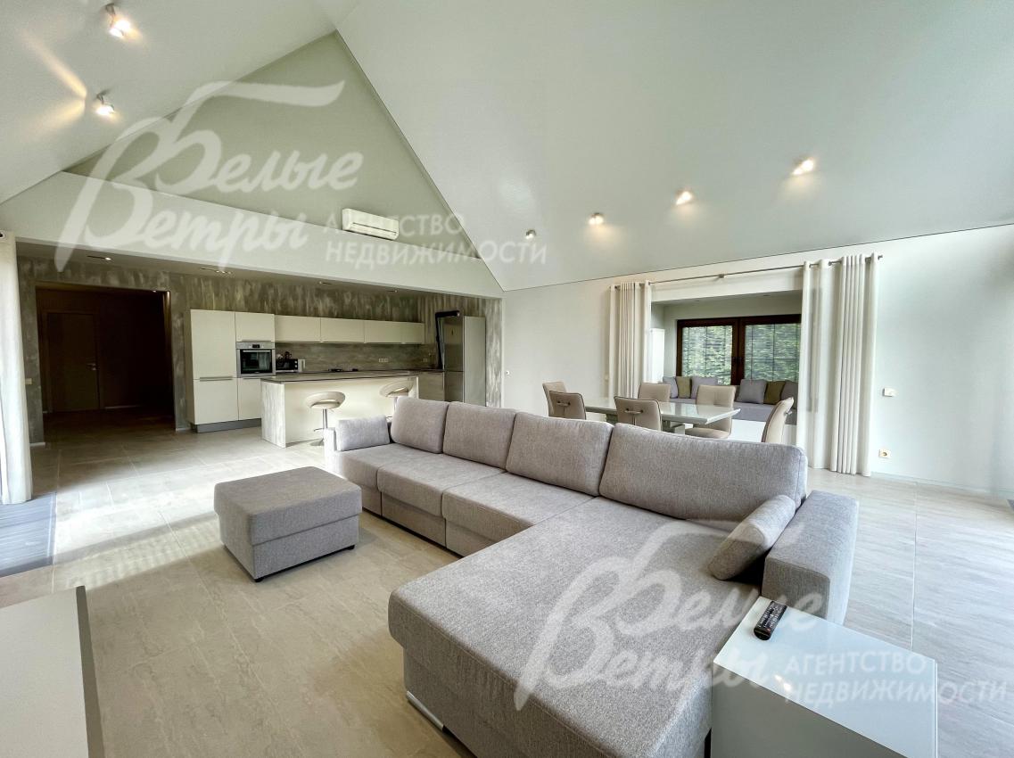 Светлая гостиная-столовая с панорамными окнами и высоким потолком