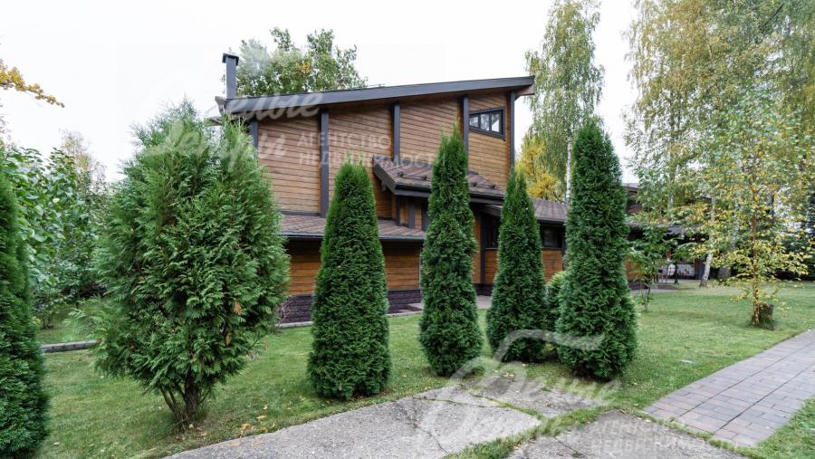 Участок с многочисленными декоративными деревьями и кустарниками (туи, сосны, ивы)