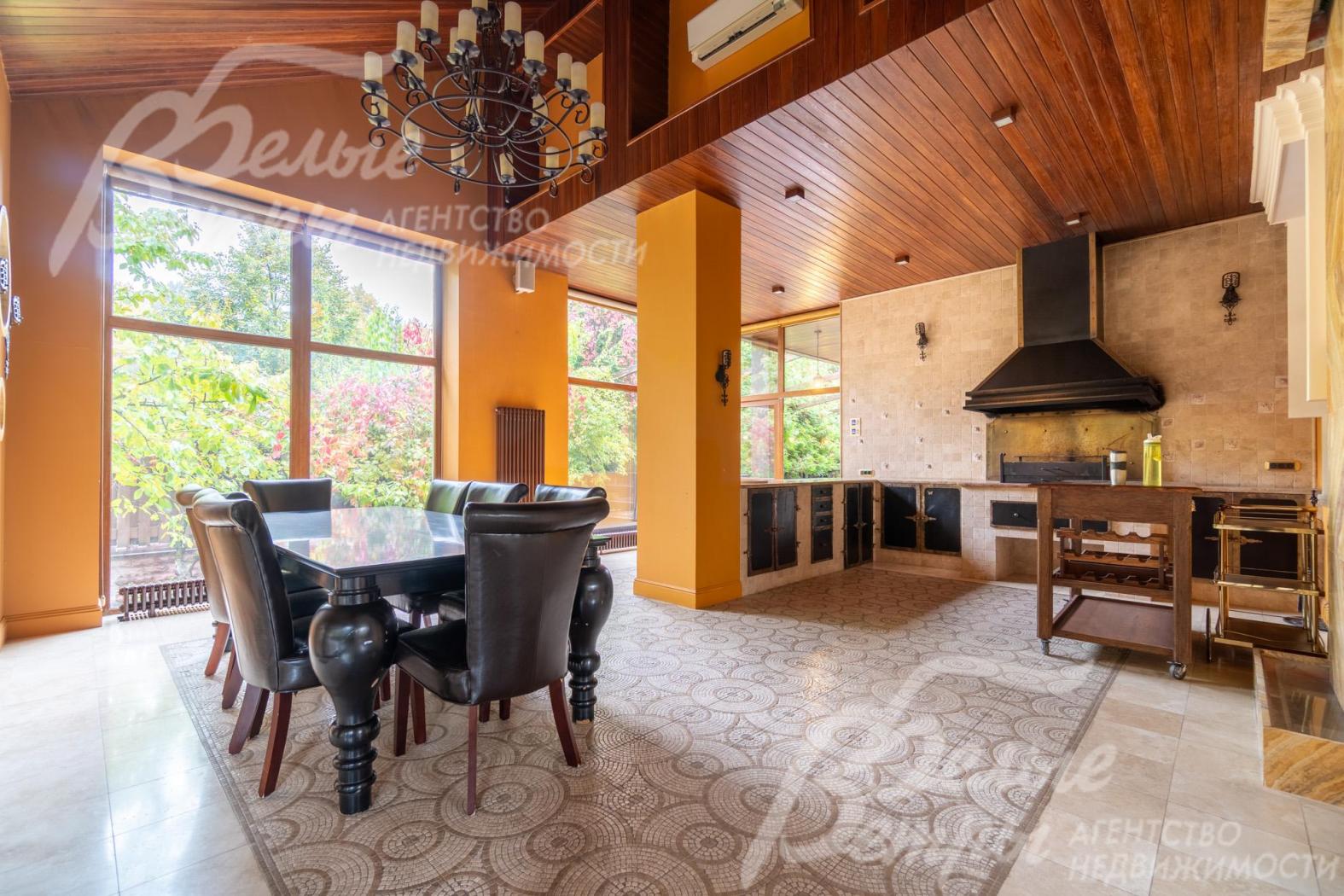 На тёплой террасе – обеденная группа, кухонная мебель, мангал с вытяжкой