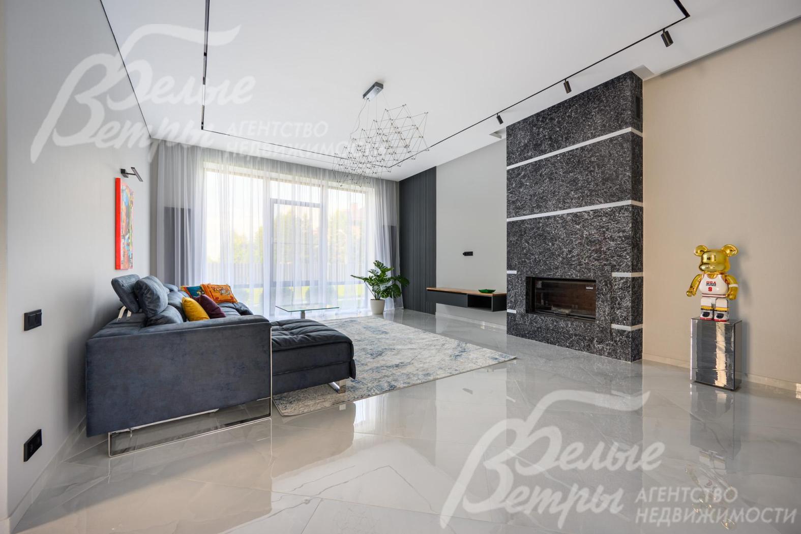Зона гостиной с панорамным окном и камином с мраморным порталом до потолка