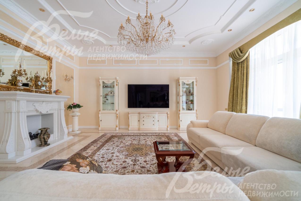 Зона гостиной. В ней установлен большой угловой диван с журнальным столиком, витринные шкафы, телевизор LG с диагональю 63 дюйма