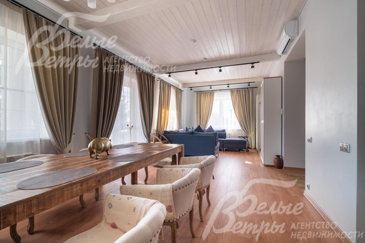 Объединённая зона кухни-столовой-гостиной в основном доме наполнена светом за счёт большой площади остекления