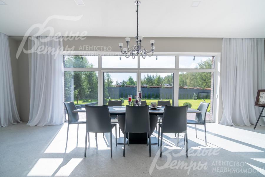 В столовой - обеденный стол (BoConcept (Дания) из шпона ореха на 8-12 персон, панорамное окно с тюлем на скрытом карнизе с выходом на участок