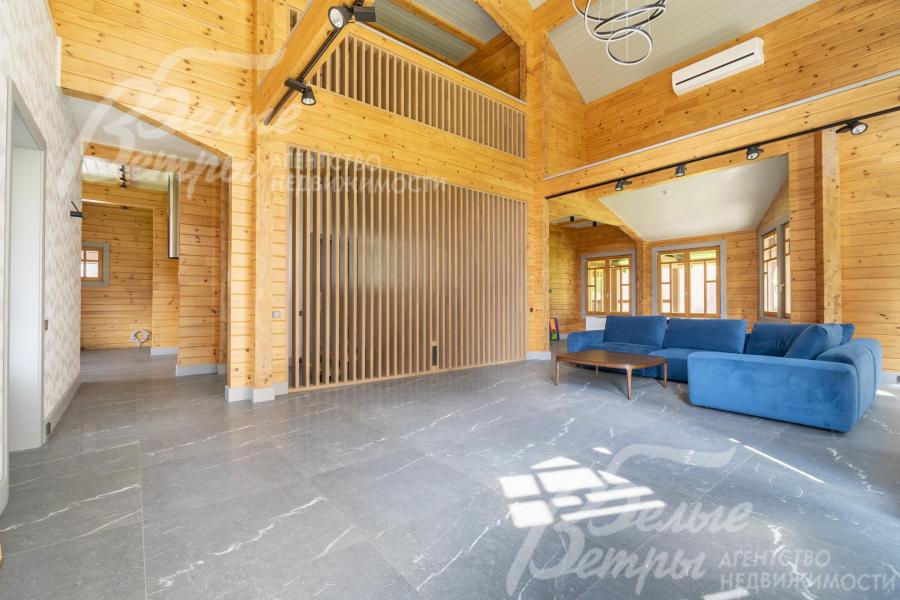 Пространство гостиной от лестницы изящно отделяет декоративная стена из массивных натуральных дубовых реек 