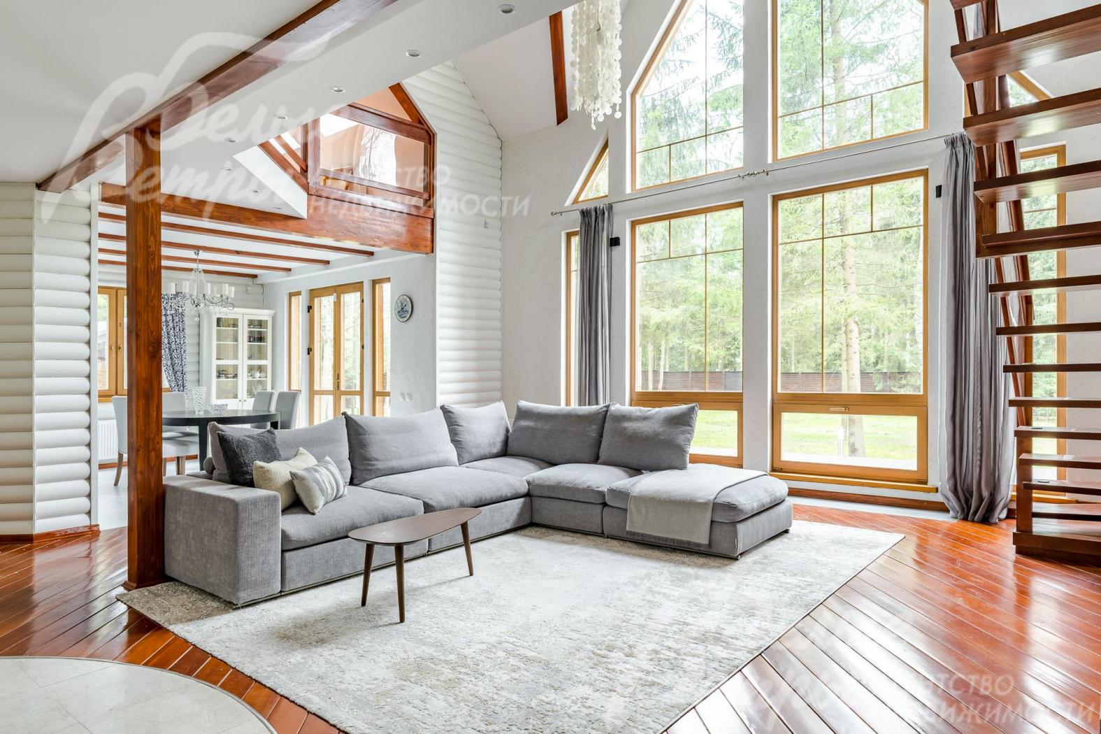 Двухсветная гостиная наполняет дом естественным светом. Огромные стекло-пакеты из лиственницы