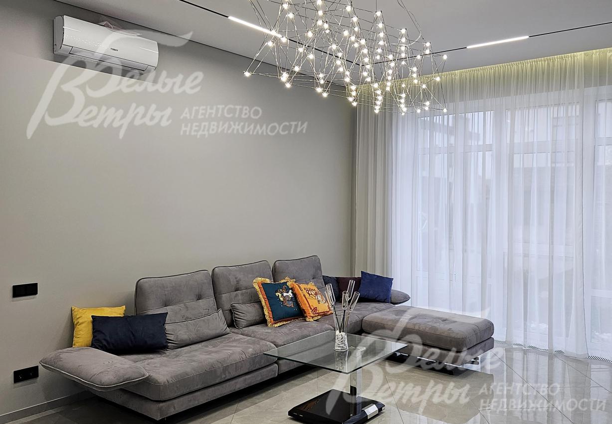 В гостиной - кондиционер и большой диван. Интерьер дома дополнен дизайнерскими люстрами и трековым освещением