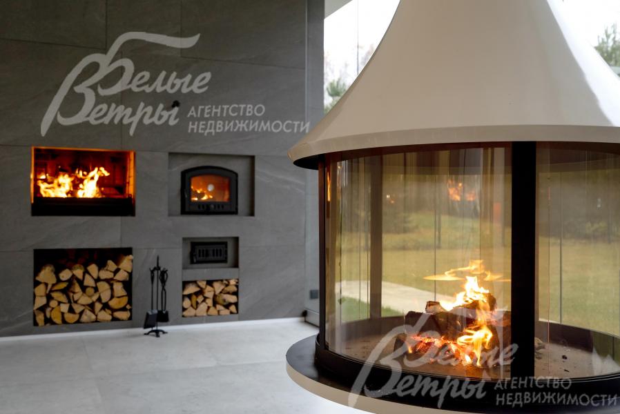 На крытой террасе-барбекю установлен эффектный подвесной камин, подовая печь, есть небольшая дровница