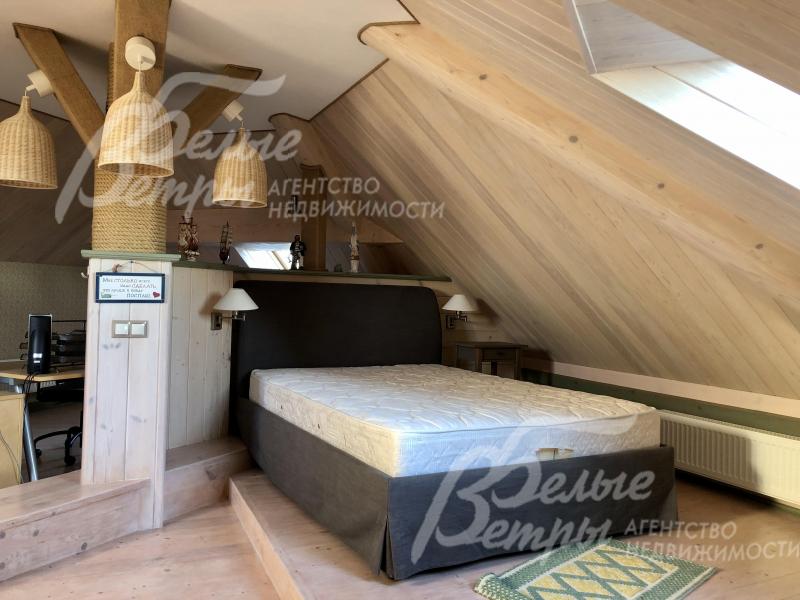 Зона для отдыха и релакса с кроватью и столом на мансарде