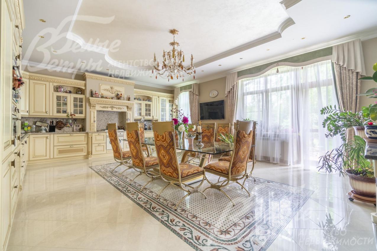 Кухня-столовая с большим окном, укомплектована гарнитуром и обеденной группой