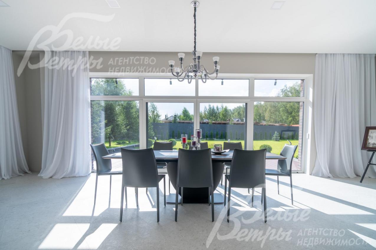 В столовой - обеденный стол (BoConcept (Дания) из шпона ореха на 8-12 персон, панорамное окно с тюлем на скрытом карнизе с выходом на участок