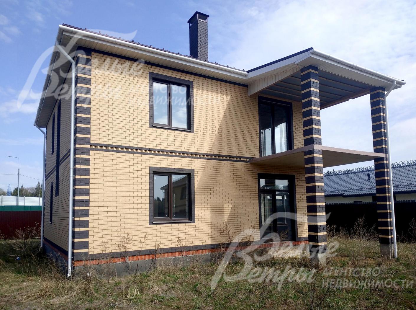 Дом облицован кирпичом двух цветом: коричного оттенка и цвета "солома"