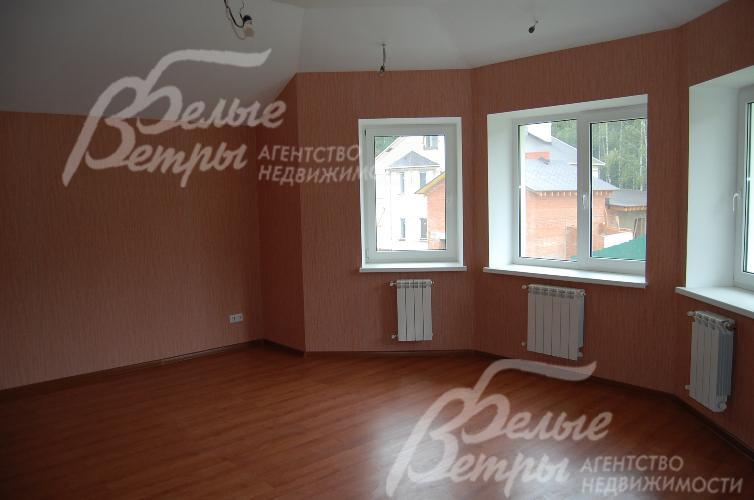 Спальня с эркерным окном смотрит на сосновую аллею, высаженную перед домом