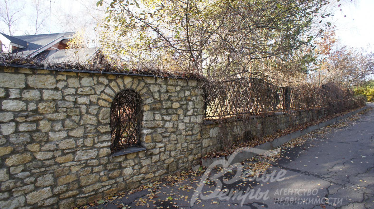 Ограждение участка из натурального камня и прозрачной ковки