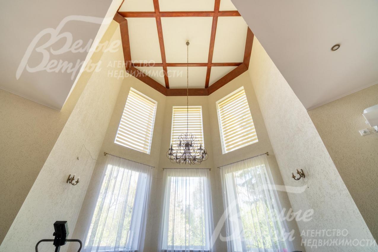 Гостиную украшают элегантные шторы и люстра