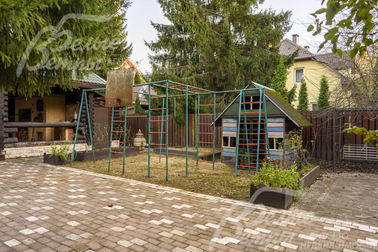 Рядом с беседкой - детский городок с турниками, качелями и домиком