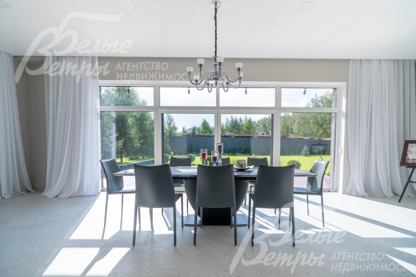 В столовой - обеденный стол (BoConcept (Дания) из шпона ореха на 8-12 персон, панорамное окно с тюлем на скрытом карнизе с выходом на участок