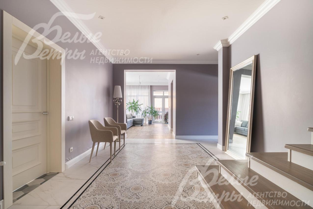 В просторном холле - «плиточный ковёр» Vitra (Турция), установлены белые шпонированные межкомнатные двери производителя «Эталон»