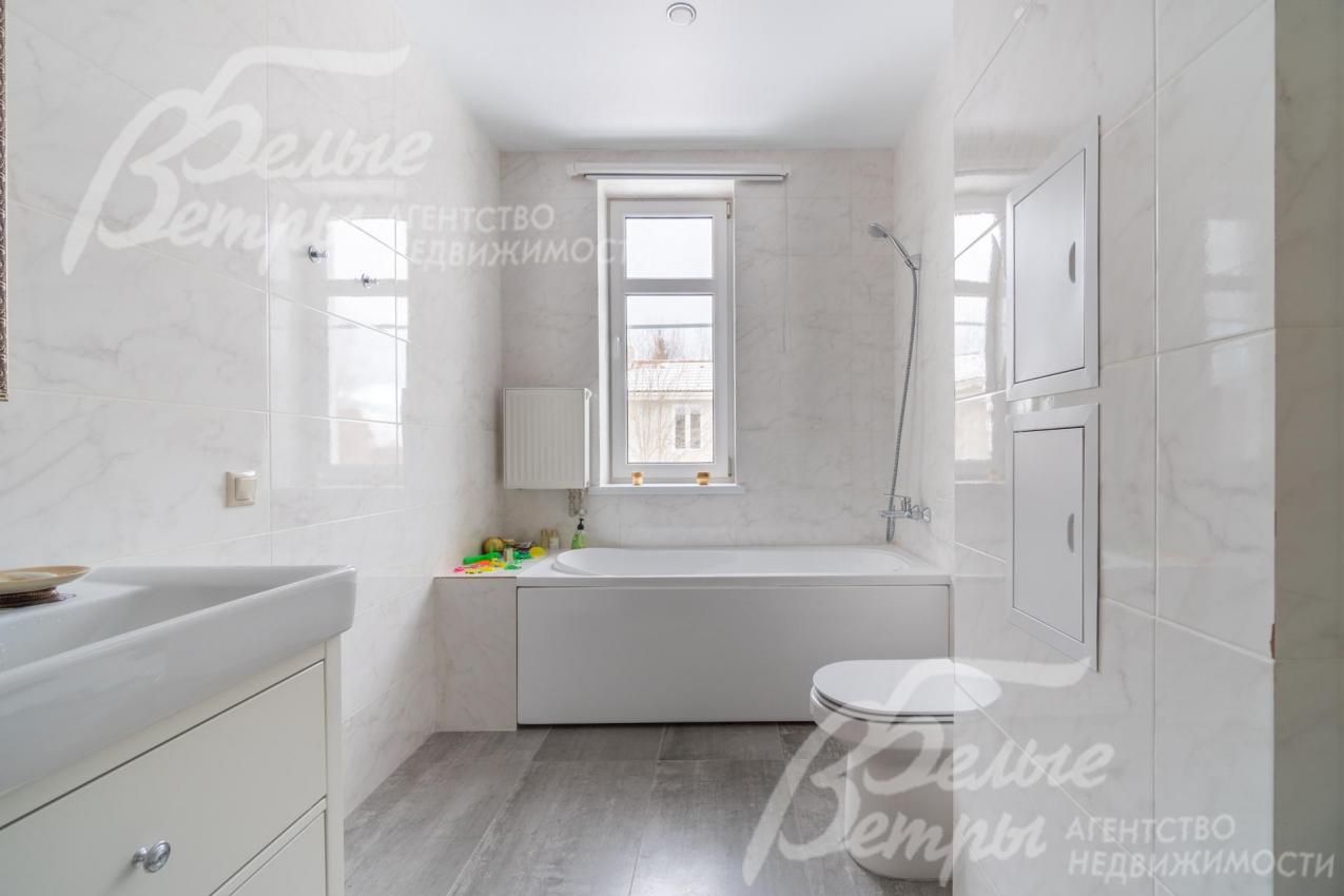 Просторный санузел с отделкой под белый мрамор