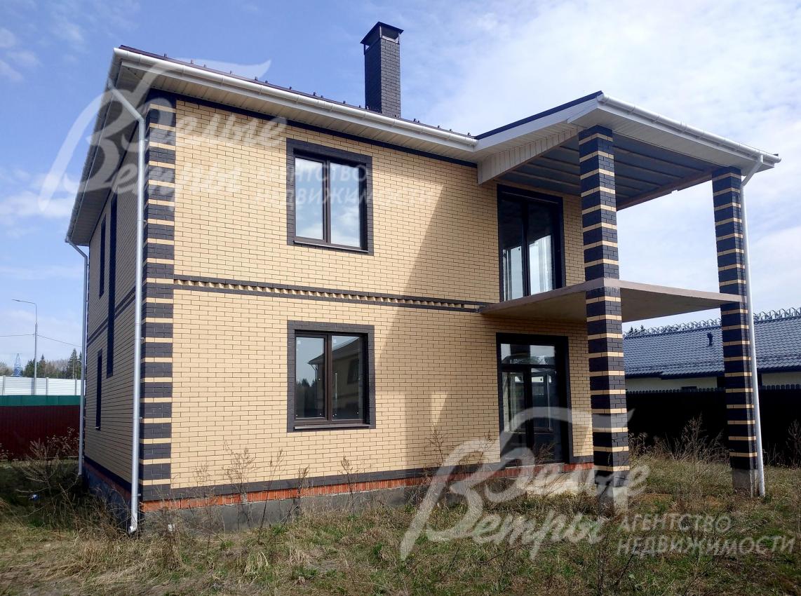 Дом облицован кирпичом двух цветом: коричного оттенка и цвета "солома"