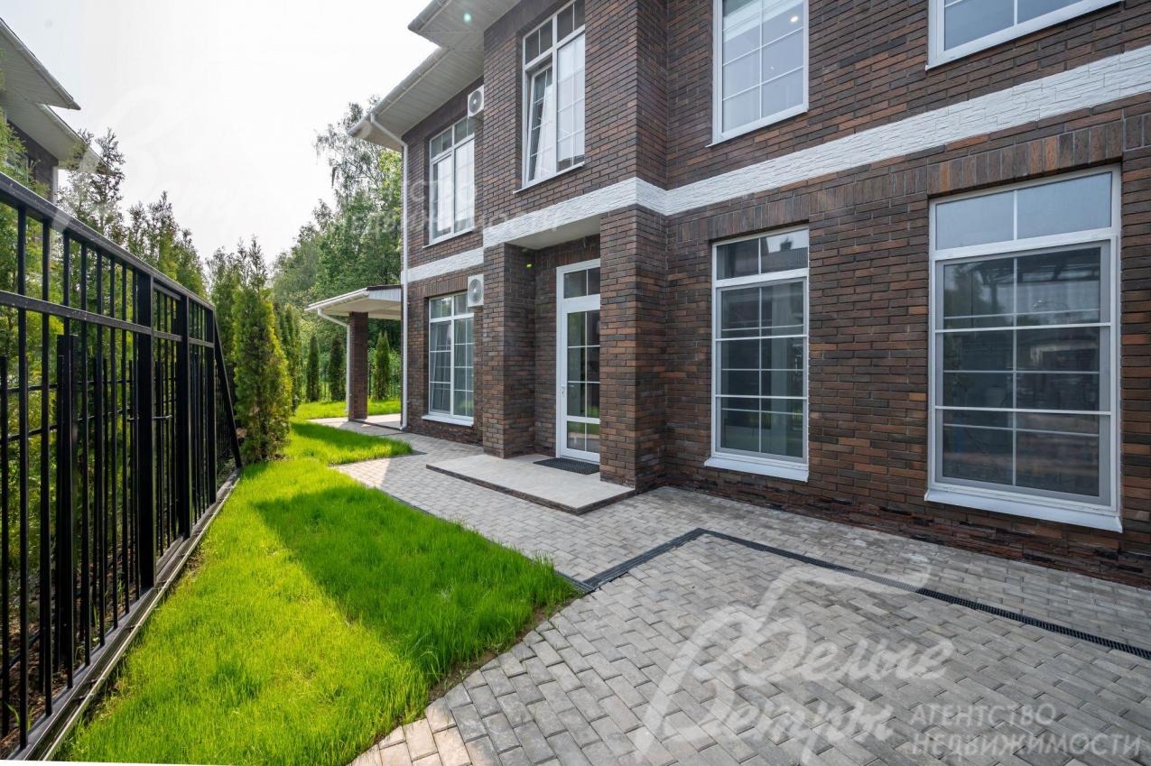 Благоустроенный участок огорожен металлическим забором.