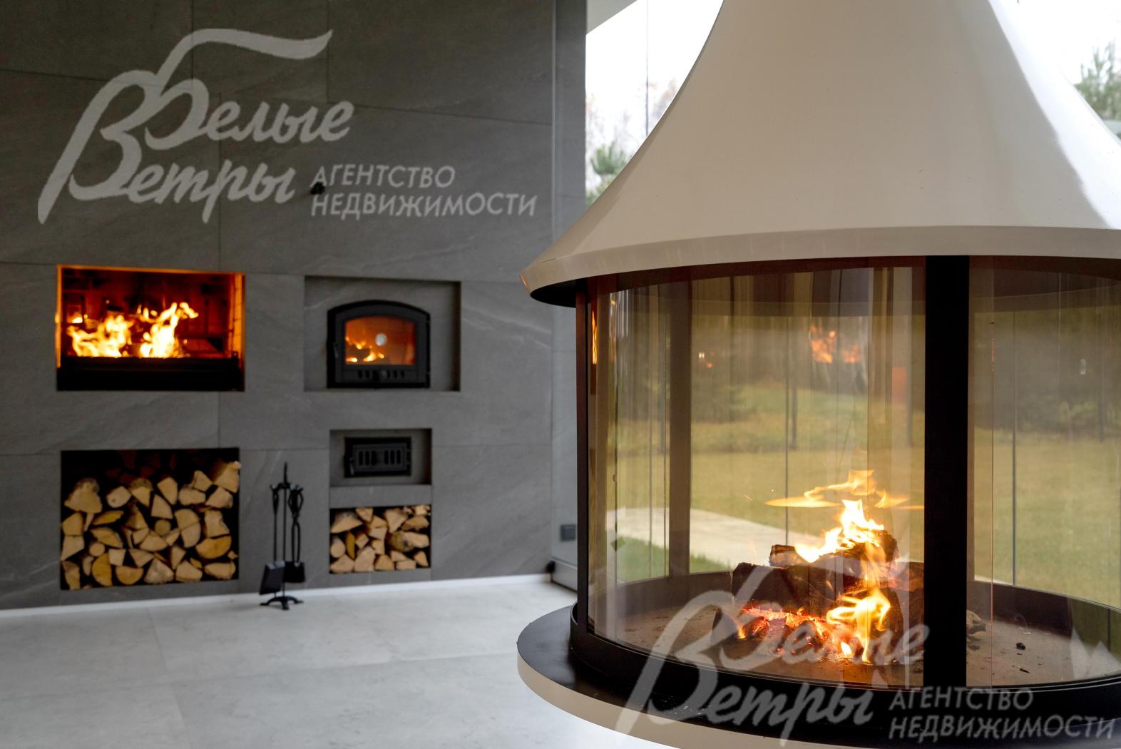 На крытой террасе-барбекю установлен эффектный подвесной камин, подовая печь, есть небольшая дровница