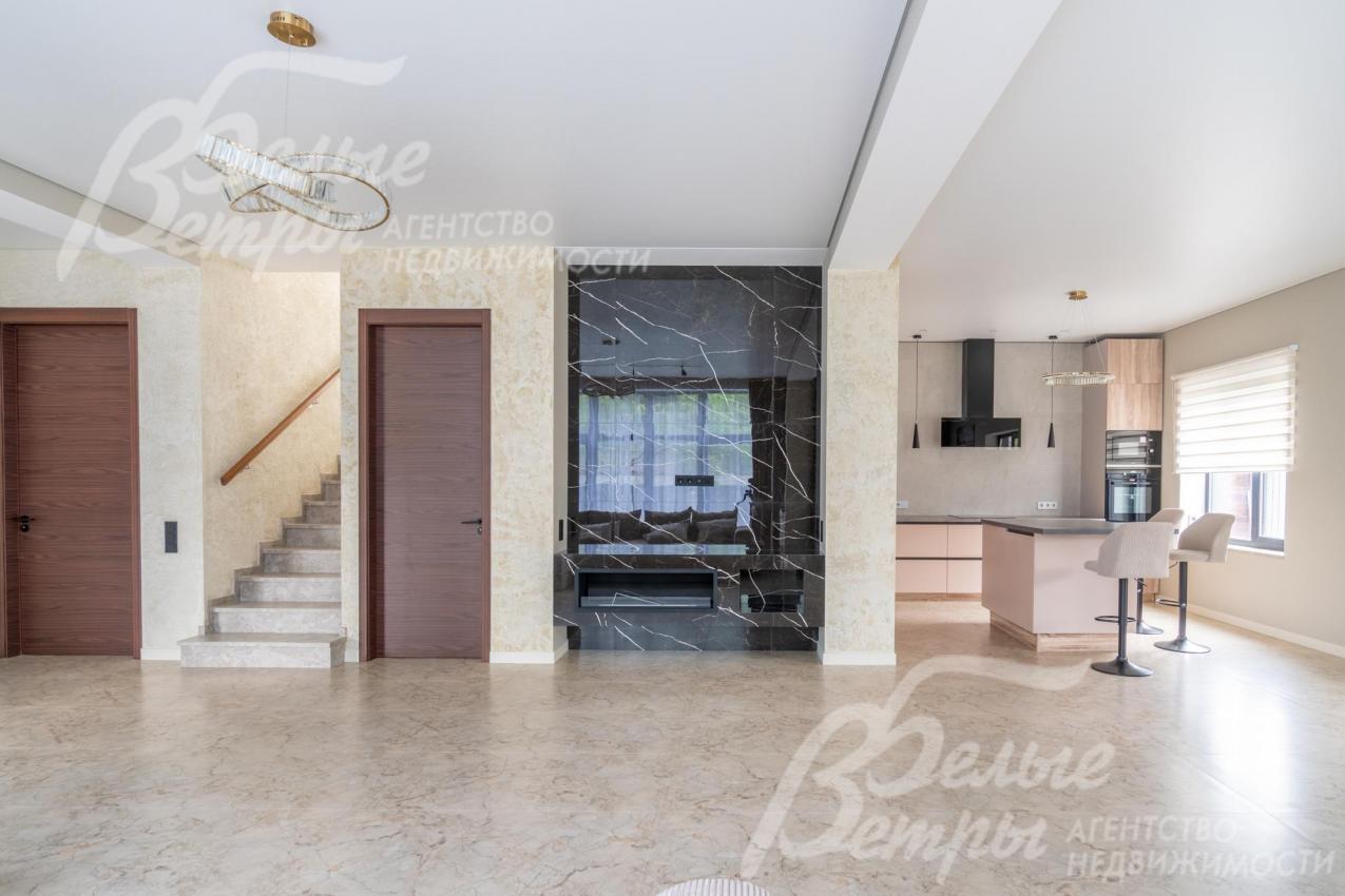 Стены зоны кухни-столовой-гостиной окрашены в светлый цвет, установлены высокие контрастные двери